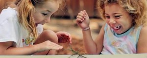 Two girls playing with a stick bug