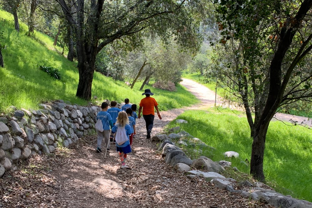 Teacher leading children on an excursion near the school grounds