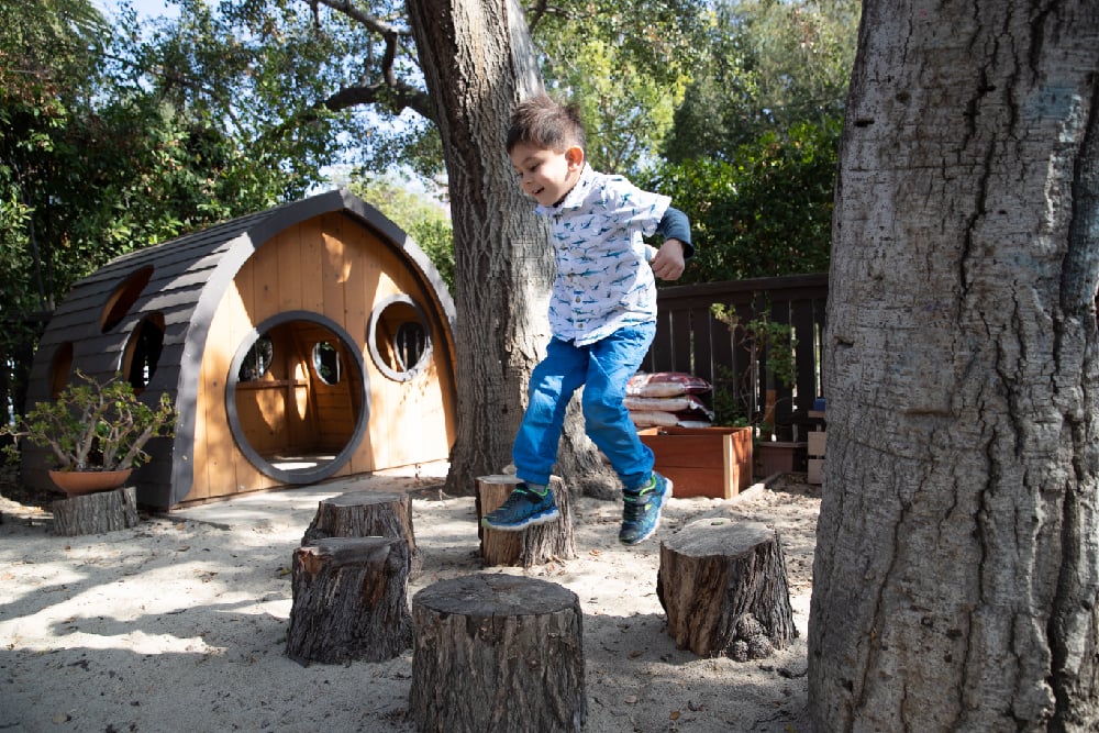 Child jumping in outdoor learning environment