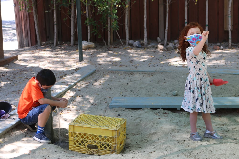 Children wearing masks and learning outdoors