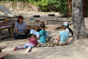 Children learning with teacher outdoors